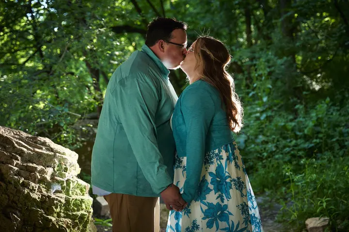 Kimberly and Stephen kissing by the rocks